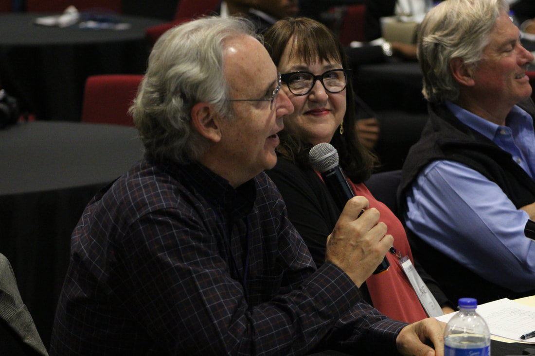 Judge speaking into a microphone during a TIME Challenge discussion