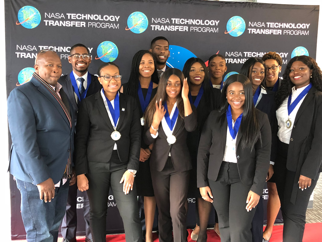 TIME Challenge medal recipients and organizers posing together before the NASA backdrop
