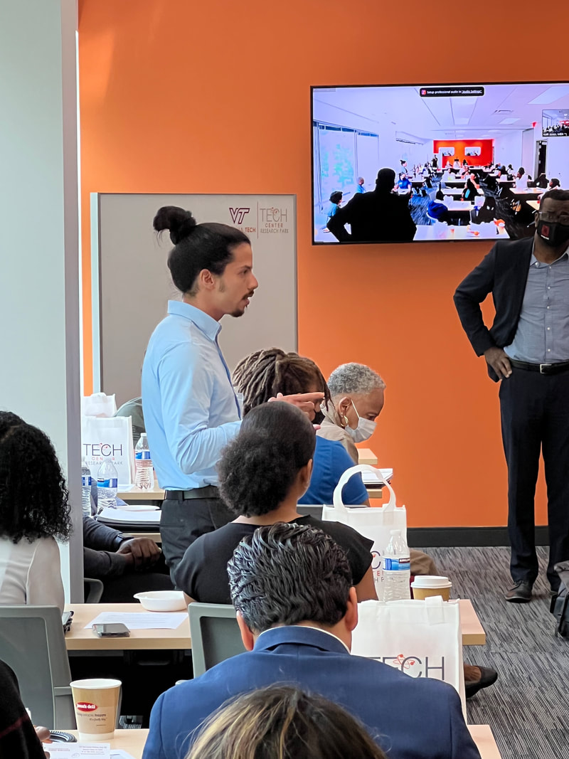 Participant in a light blue shirt standing to speak during the workshop