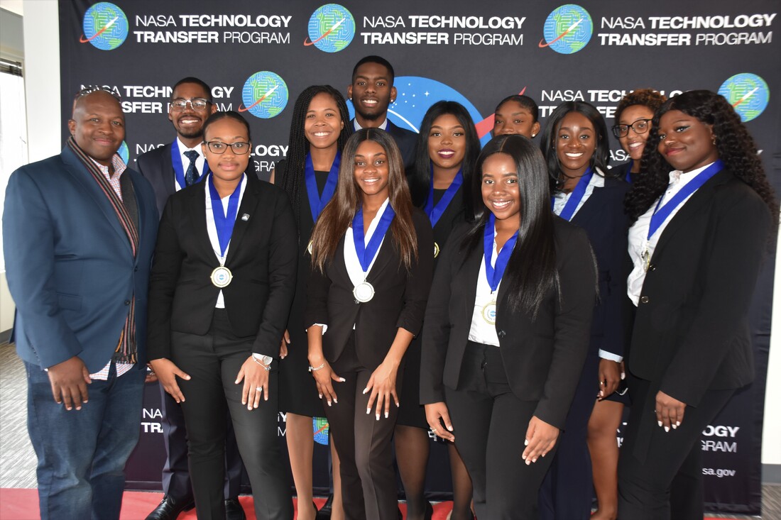 Medal-winning TIME Challenge students posing with organizers before the NASA backdrop