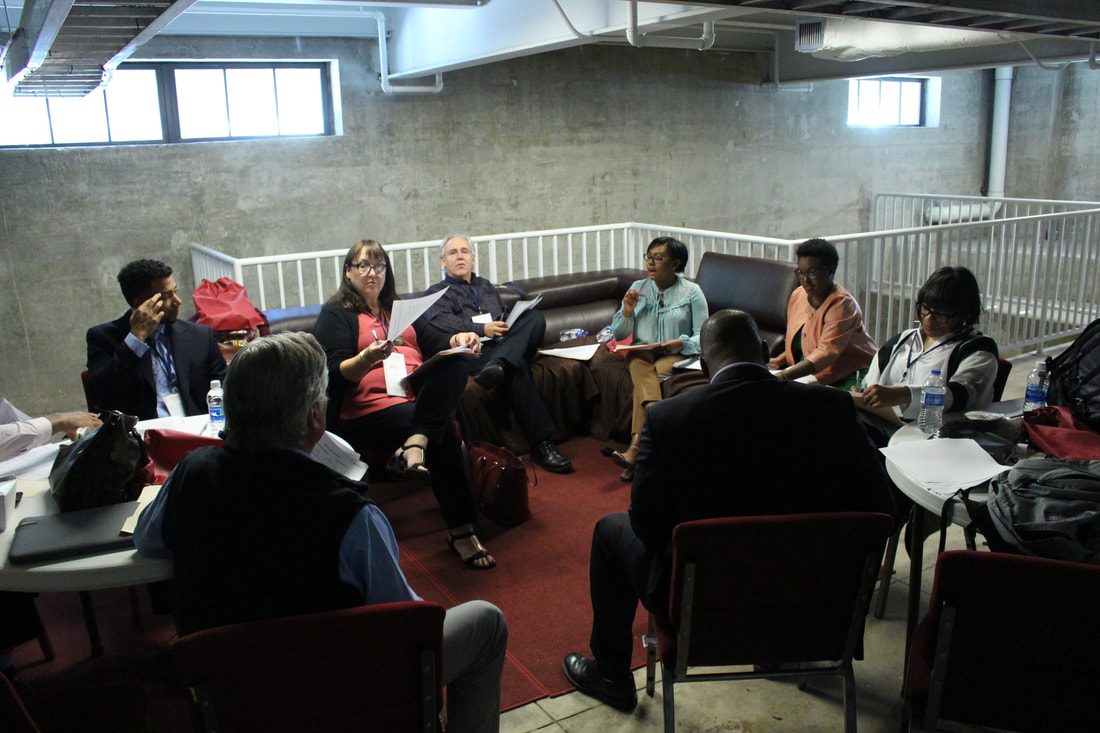 TIME Challenge judges deliberating around a table in a meeting room