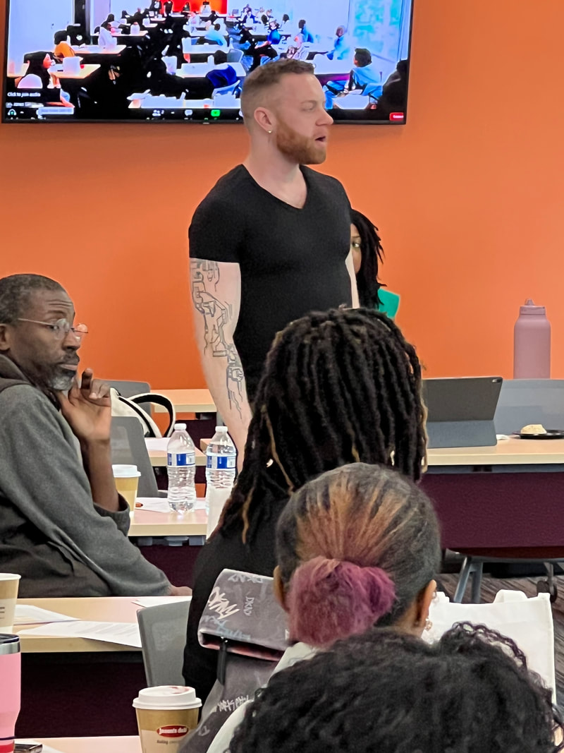 Participant in a black shirt standing to address the workshop group