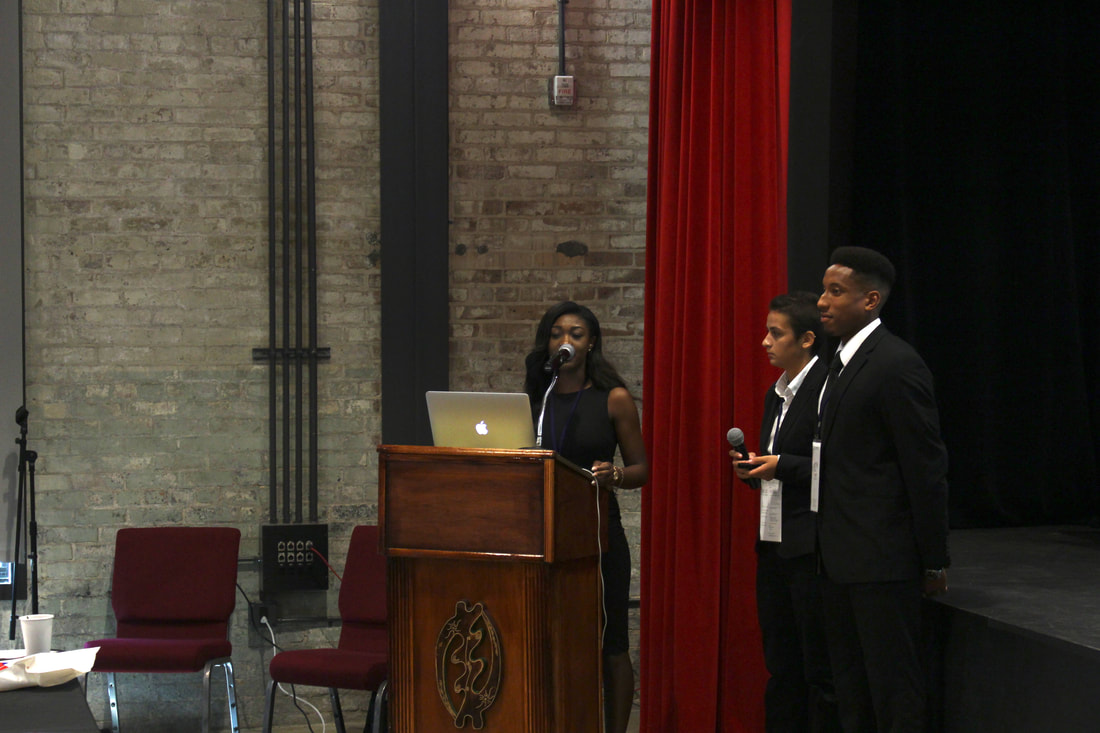 Tree of Life team members presenting at the auditorium podium