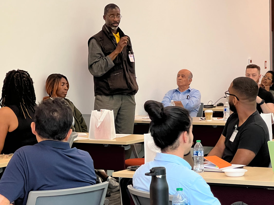 Participant holding a microphone and speaking to seated workshop attendees