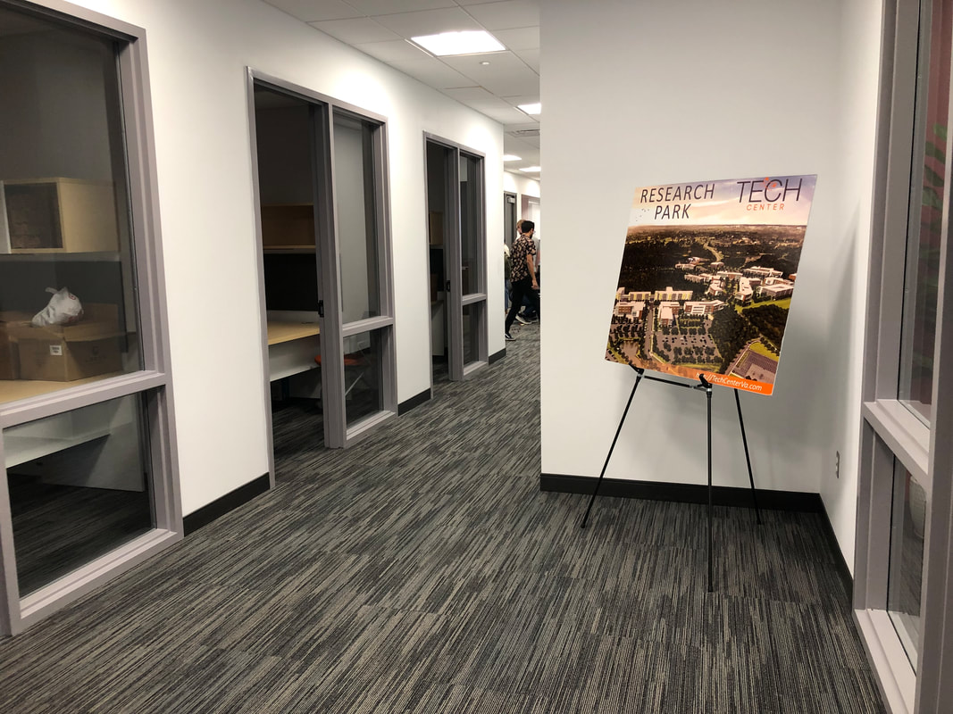 Hallway at the workshop venue with an event poster displayed on an easel