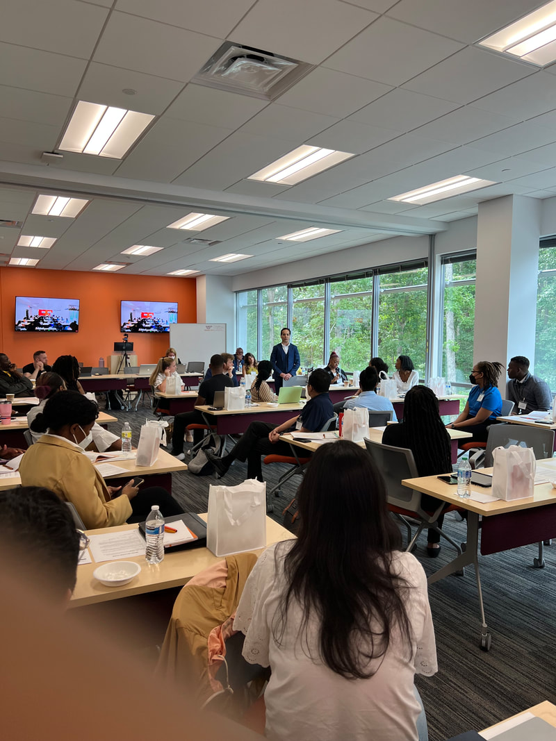 Wide view of attendees seated at tables during the workshop discussion