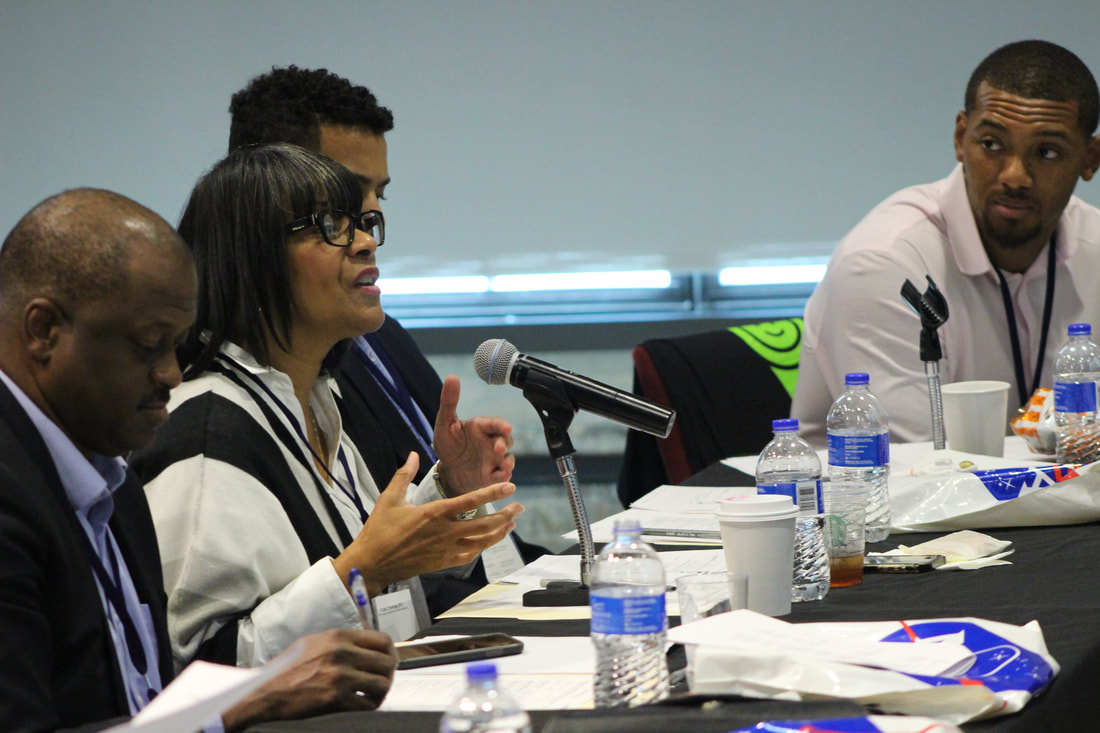Judges discussing a presentation at a table with microphones