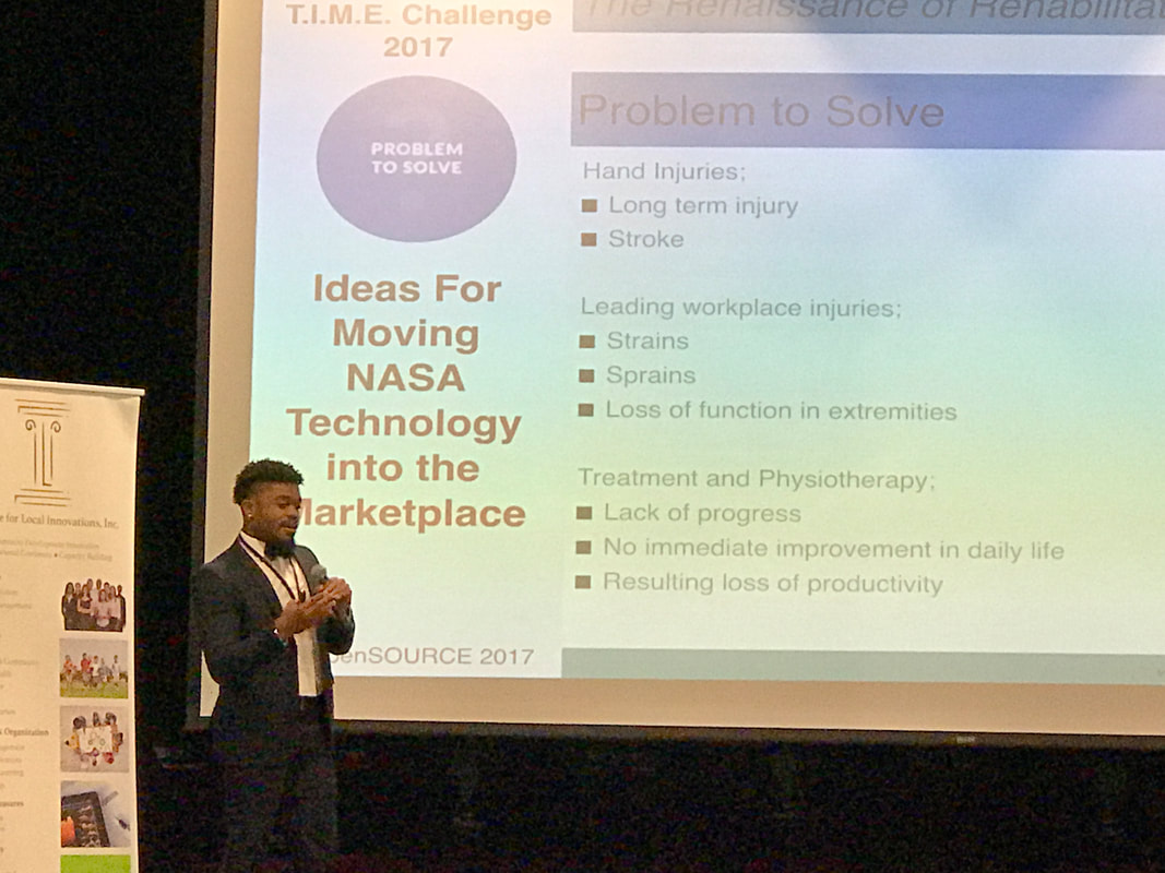 Presenter explaining ideas for moving NASA technology into the marketplace beside a projected TIME Challenge slide